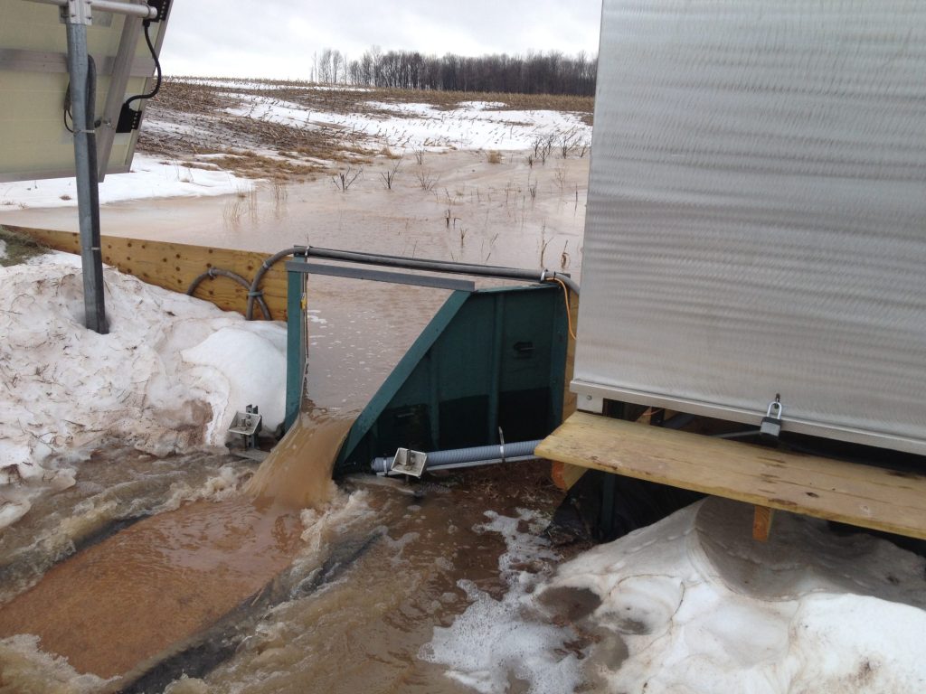 Cloudy water running through a flume in the late winter.